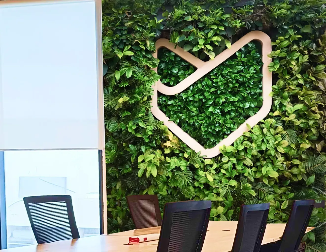 HappyFox colleagues gathering around the HappyFox office living wall.